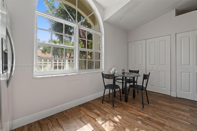 dining room with dark hardwood / wood-style flooring and lofted ceiling