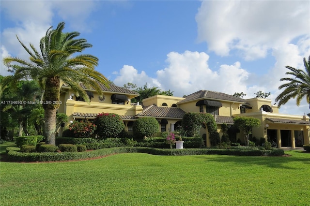 mediterranean / spanish-style house featuring a front yard