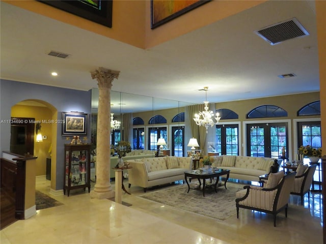 interior space with ornate columns, a chandelier, and french doors