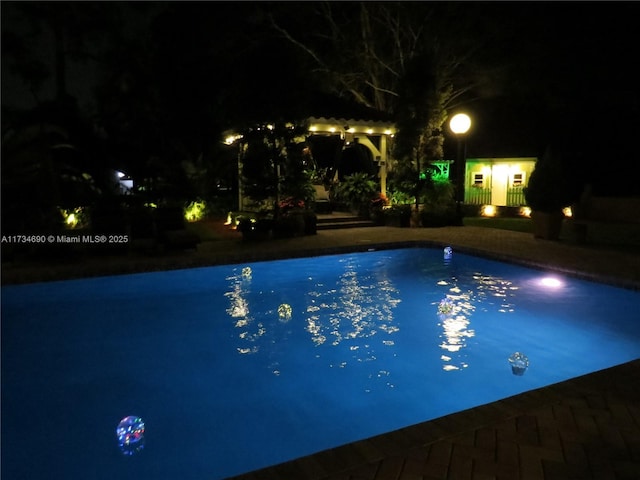 view of pool at twilight