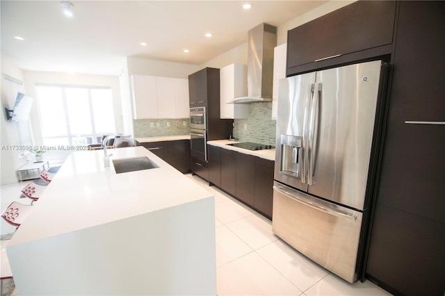 kitchen with range hood, white cabinetry, sink, a kitchen island with sink, and stainless steel appliances