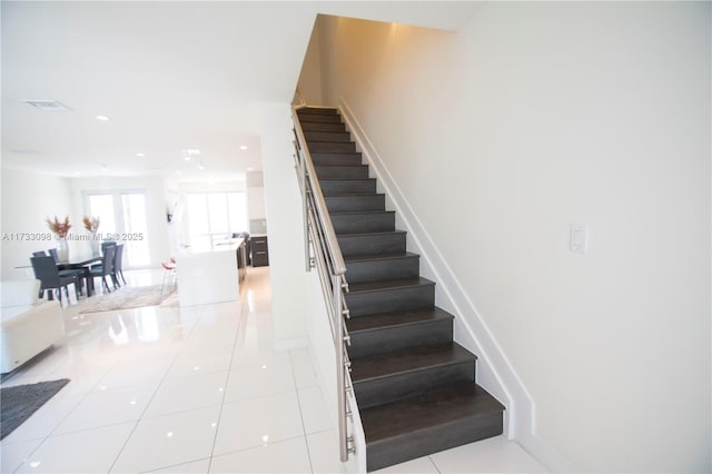 stairway with tile patterned floors