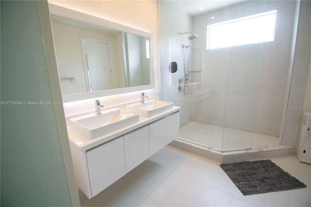 bathroom with tile patterned floors, vanity, and a tile shower