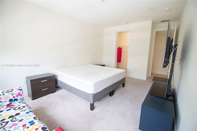 carpeted bedroom with a walk in closet