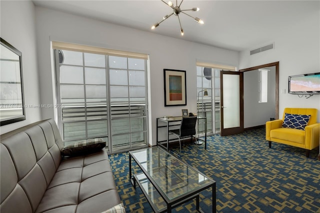 carpeted living room with an inviting chandelier and french doors