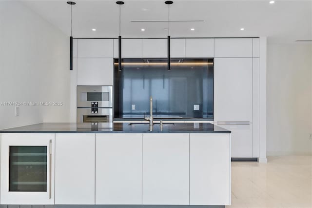 kitchen featuring sink, wine cooler, white cabinets, decorative light fixtures, and stainless steel double oven