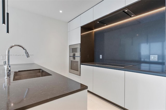 kitchen featuring sink, white cabinetry, dark stone countertops, black electric stovetop, and stainless steel double oven