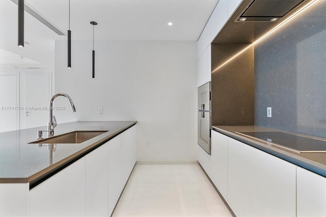 kitchen featuring white cabinetry, sink, and decorative light fixtures