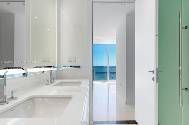 bathroom featuring a water view, a wall of windows, and vanity