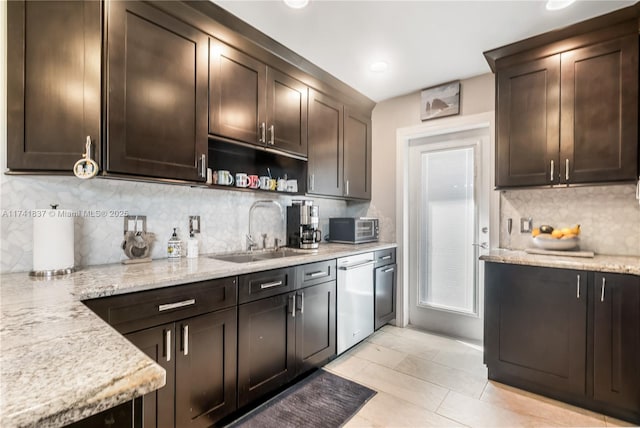 kitchen featuring light stone counters, sink, dark brown cabinets, and dishwasher