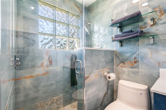 bathroom featuring vanity, a shower with shower door, tile walls, and toilet