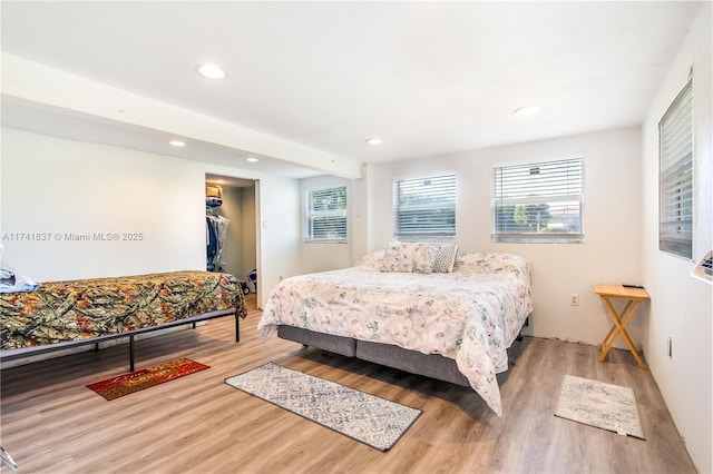 bedroom featuring hardwood / wood-style flooring, a spacious closet, and a closet