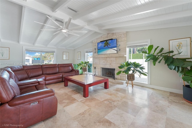 living room with vaulted ceiling with beams, ceiling fan, a fireplace, and a wealth of natural light