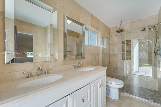 bathroom featuring tile patterned floors, toilet, an enclosed shower, tile walls, and vanity