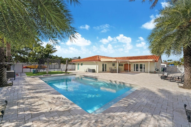 view of swimming pool featuring french doors, a patio area, and a trampoline