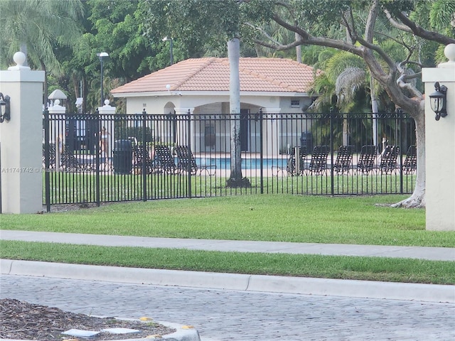 view of gate with a fenced in pool, fence, and a lawn