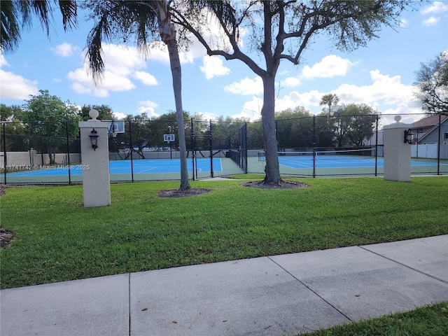 view of home's community with a tennis court, a yard, and fence