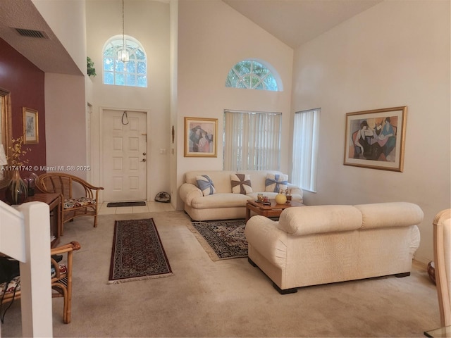 living room featuring high vaulted ceiling, visible vents, and light colored carpet