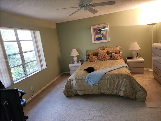 bedroom with a textured ceiling, baseboards, a ceiling fan, and light colored carpet