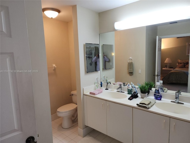 ensuite bathroom with ensuite bathroom, tile patterned flooring, a sink, and toilet