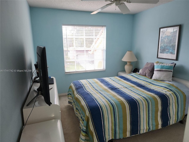 bedroom with a textured ceiling, carpet flooring, and a ceiling fan