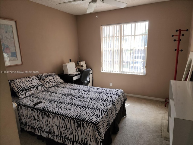 bedroom with light carpet, a textured ceiling, a ceiling fan, and baseboards