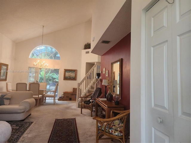 living room featuring a notable chandelier, visible vents, carpet flooring, high vaulted ceiling, and stairs