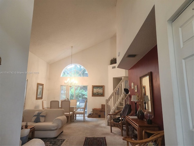 living area with light carpet, visible vents, stairs, high vaulted ceiling, and a notable chandelier