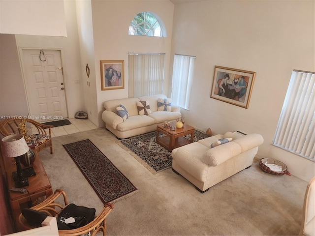 living room featuring tile patterned flooring, carpet flooring, and a towering ceiling