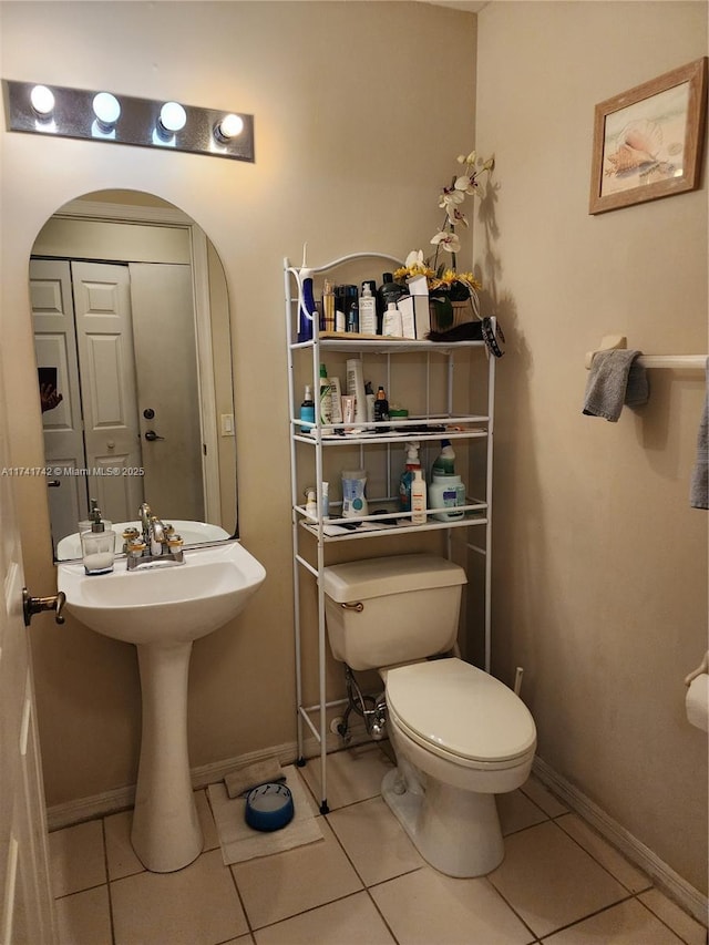 bathroom with tile patterned flooring, toilet, and baseboards