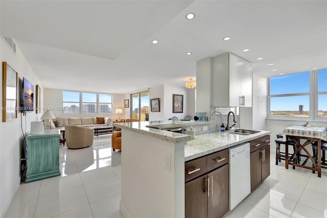 kitchen featuring a sink, visible vents, dishwasher, and light tile patterned flooring