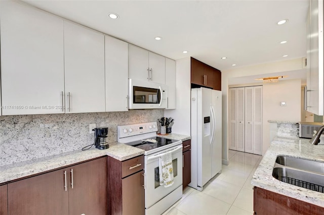 1833 S Ocean Dr Unit 1612, Hallandale Beach, FL 33009 - kitchen featuring light tile patterned floors, tasteful backsplash, a sink, light stone countertops, and white appliances
