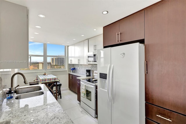 1833 S Ocean Dr Unit 1612, Hallandale Beach, FL 33009 - kitchen with white appliances, decorative backsplash, light stone counters, a sink, and recessed lighting