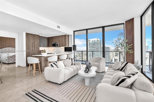 living room featuring expansive windows, visible vents, and plenty of natural light