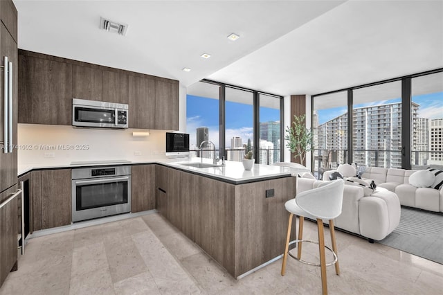 kitchen featuring stainless steel appliances, modern cabinets, a sink, and visible vents