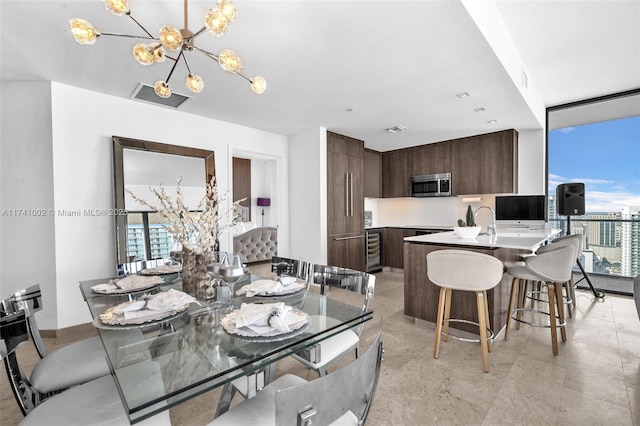 dining room featuring an inviting chandelier, beverage cooler, and visible vents