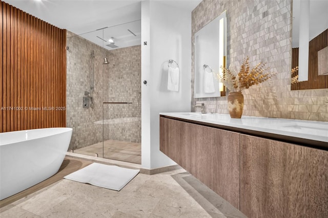 full bath featuring a sink, a soaking tub, double vanity, tasteful backsplash, and a stall shower