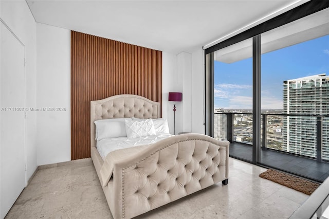 bedroom with access to exterior, a view of city, and floor to ceiling windows