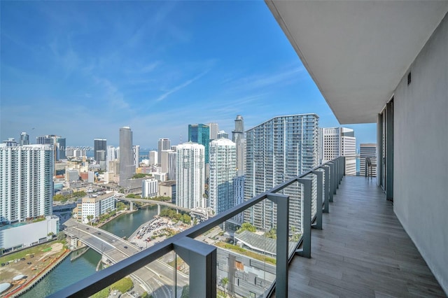 balcony featuring a water view and a city view