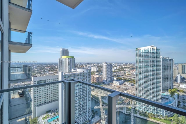 balcony with a water view and a view of city