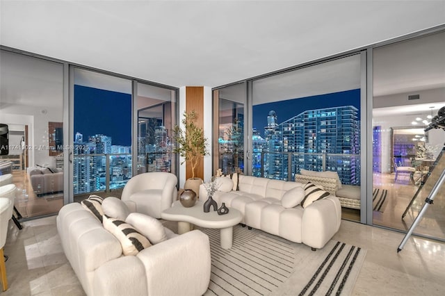 living area featuring a city view, floor to ceiling windows, visible vents, and an inviting chandelier