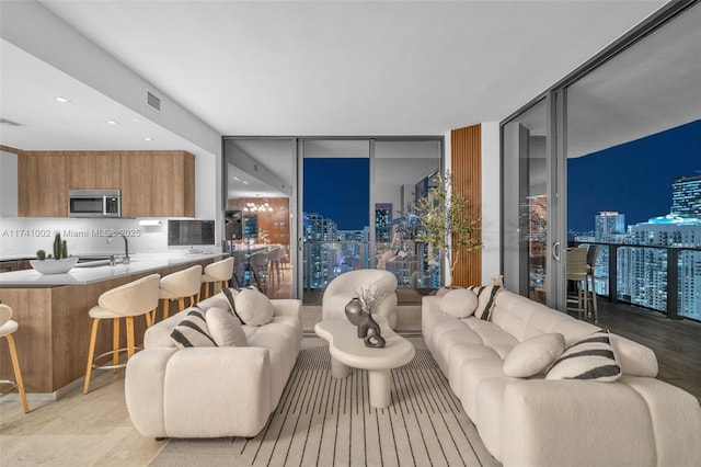 living area featuring floor to ceiling windows and visible vents