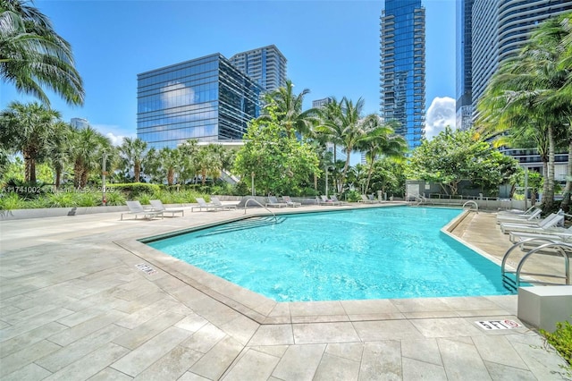 pool with a patio area and a city view