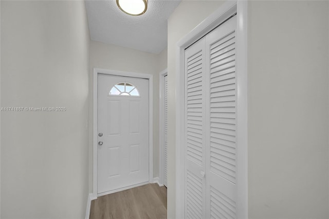 entryway featuring light hardwood / wood-style floors and a textured ceiling