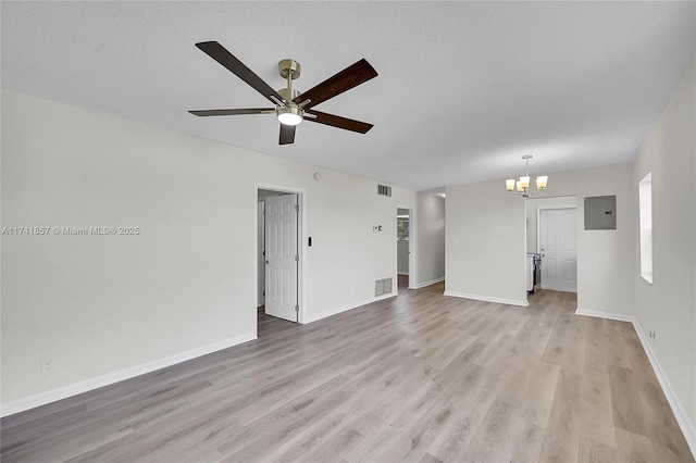 unfurnished living room featuring plenty of natural light, a textured ceiling, electric panel, and light hardwood / wood-style floors