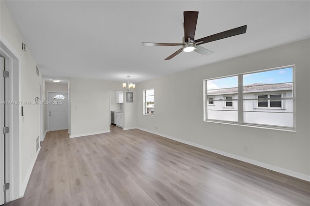 unfurnished living room featuring ceiling fan with notable chandelier and light hardwood / wood-style flooring