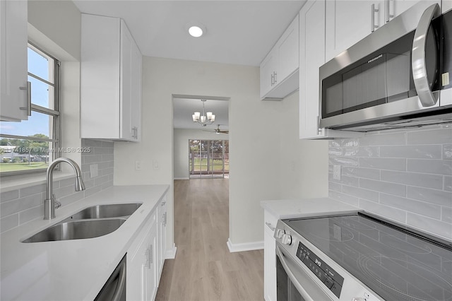 kitchen featuring sink, stainless steel appliances, white cabinets, and light wood-type flooring