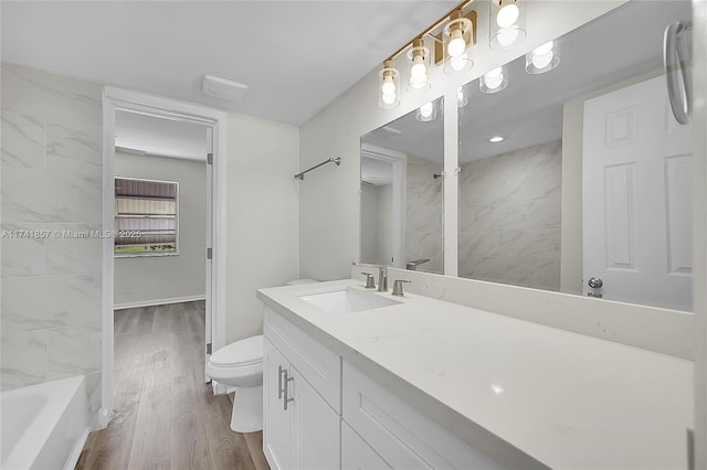 bathroom featuring wood-type flooring, toilet, and vanity