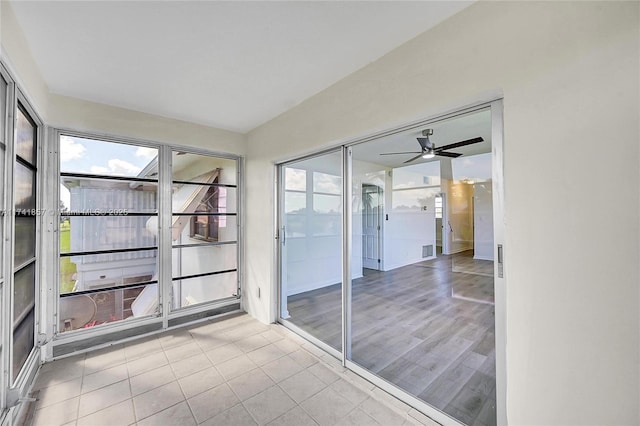 unfurnished sunroom with ceiling fan