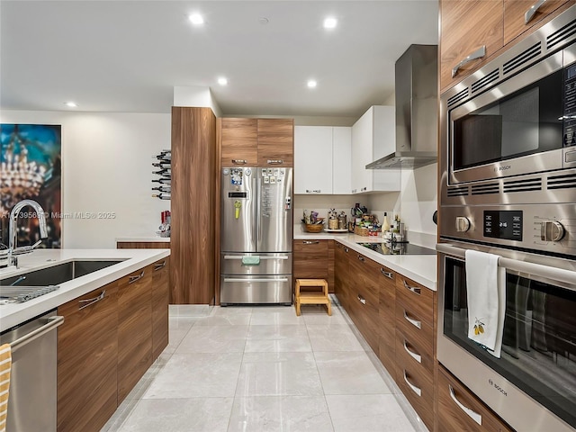 kitchen with wall chimney range hood, sink, appliances with stainless steel finishes, white cabinets, and light tile patterned flooring